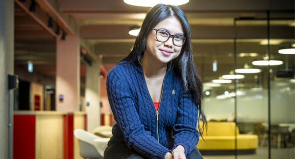 A female with glasses is sitting relaxed