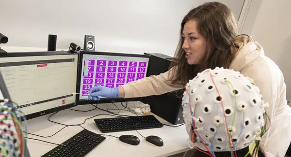 Two female students are working in the psychology lab together on an experiment