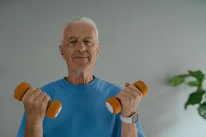 An older man holding some weights