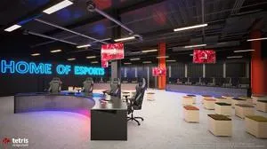 Empty gaming arena with rows of computers and a glowing sign reading 'HOME OF ESPORTS.'