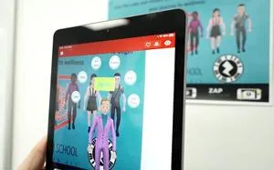 Hand holds a tablet displaying an augmented-reality wellbeing app with animated characters.
