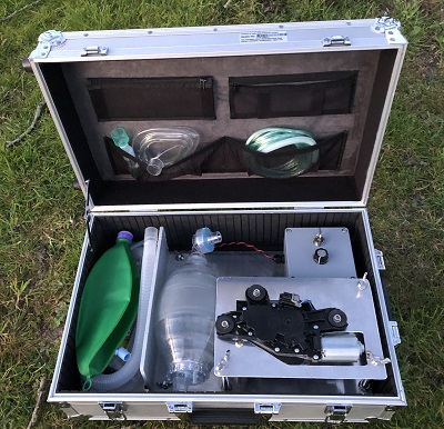 Open equipment case containing tubing, masks and components for a portable field ventilator.