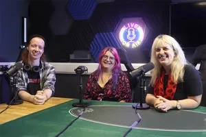 Three people sat in a podcast recording studio
