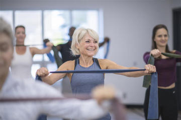 An older woman exercising with resistance bands