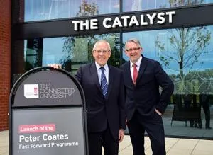Two men stood by a sign outside The Catalyst building