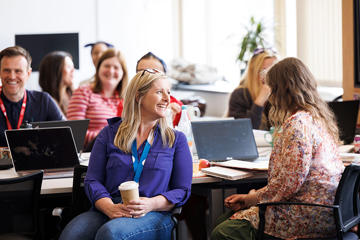 A group of adults smiling in a classroom setting