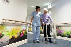Nurse and patient walking through care home