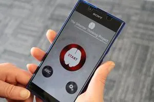 Hand holds a smartphone displaying the Smarter Thinking app with a large red 'START' button.
