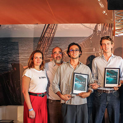 A group of seven people with three holding framed certificates