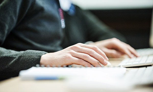 Student's hands typing on a keyboard