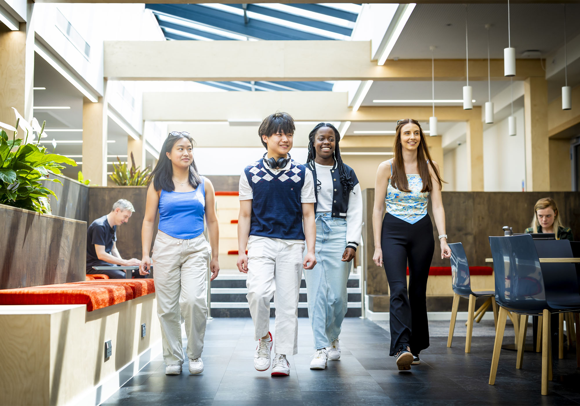 A group of students are walking through the Stafford social space
